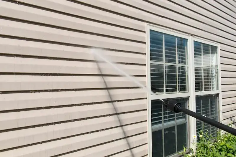 Washing vinyl siding on a house.